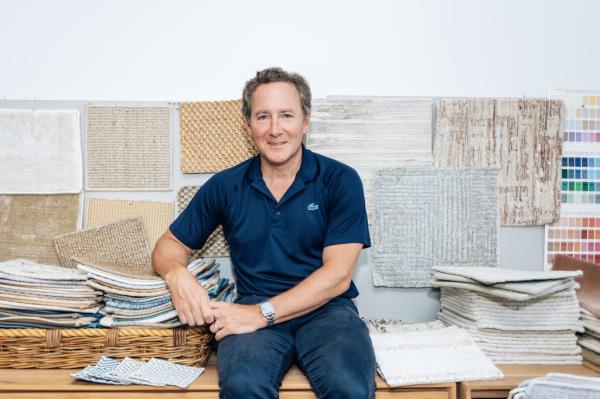 John Foley sitting on a bench with a basket of rugs in Ernesta, Manhattan on August 6, 2024